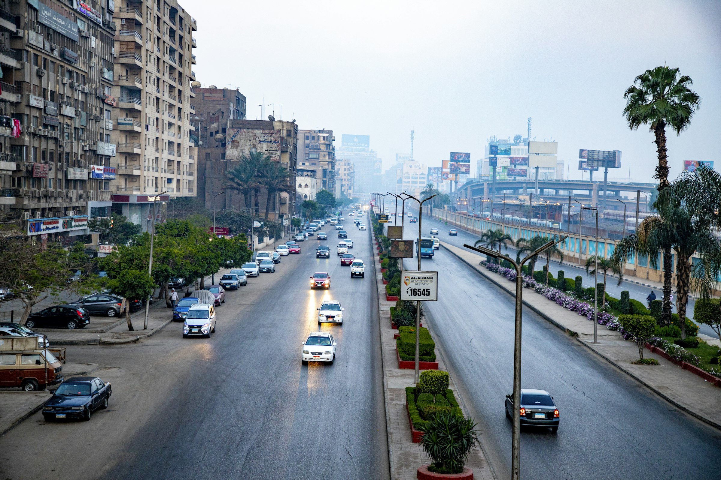 شارع في القاهرة مزدحم بحركة السيارات بجوار مبانٍ مرتفعة
